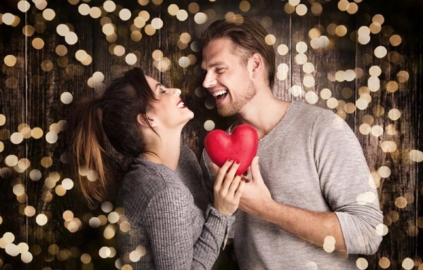 Couple laughing while they celebrate Valentine's Day on a budget.