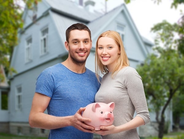 Happy couple holding a piggy bank