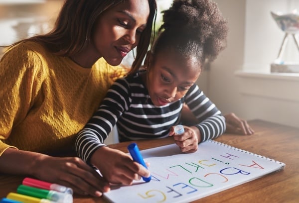 Mom with daughter writing the abc's