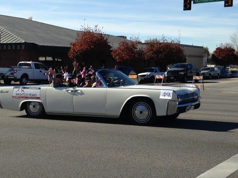 Veterans waving in a classic car