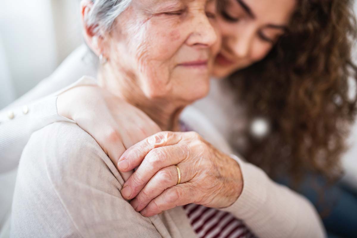 Daughter holding elderly mother