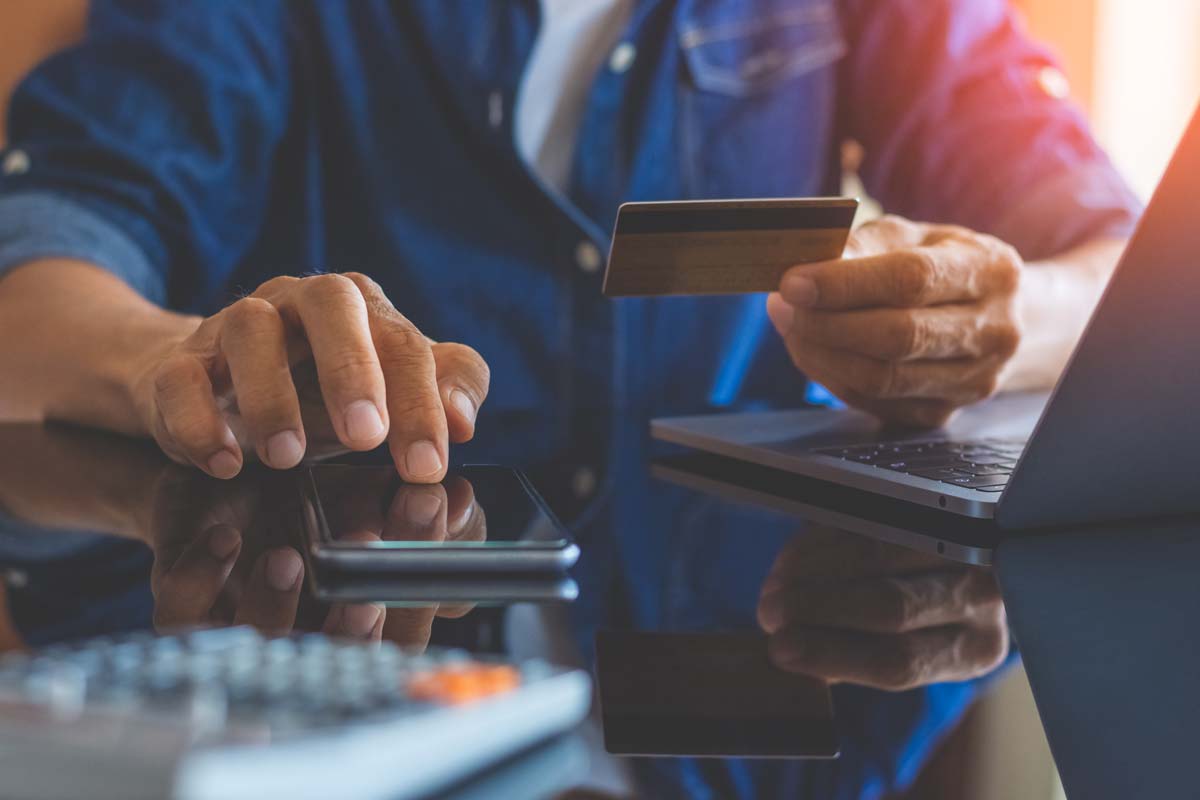 Man looking at smartphone and debit card