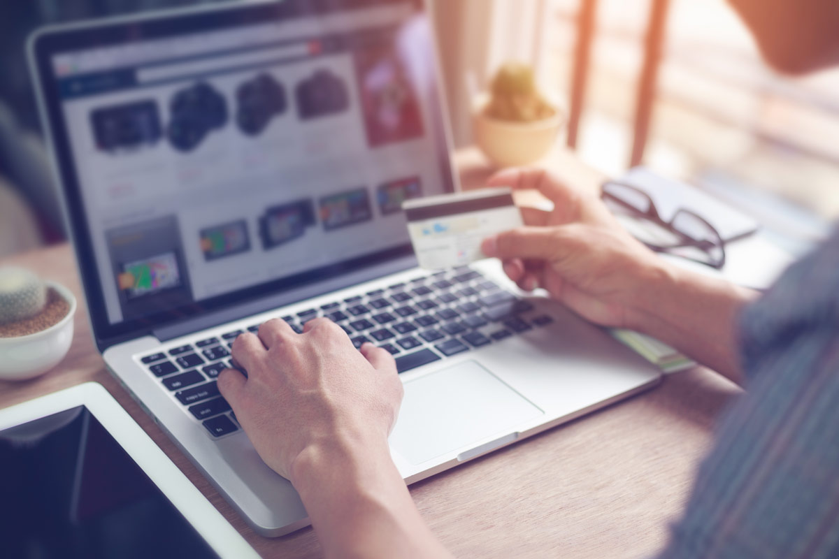 person shopping on computer while holding credit card