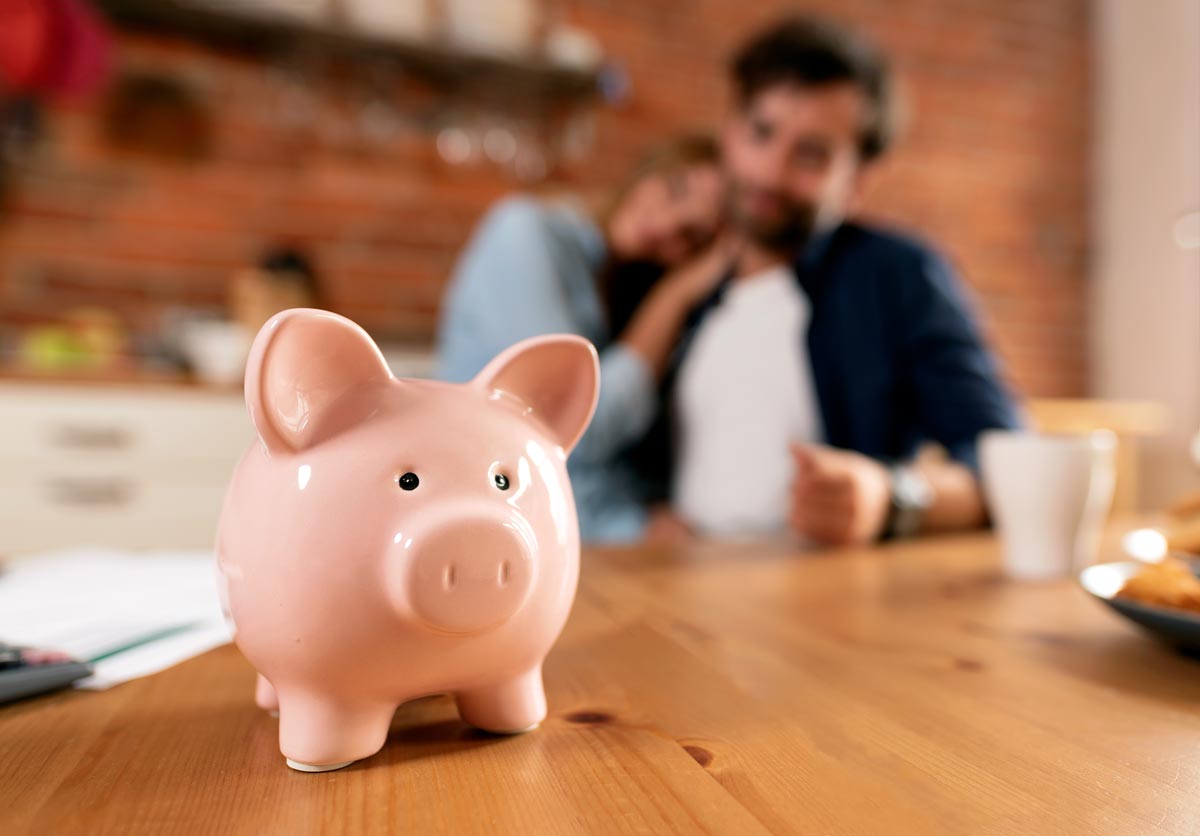 piggy bank on table in front of happy couple