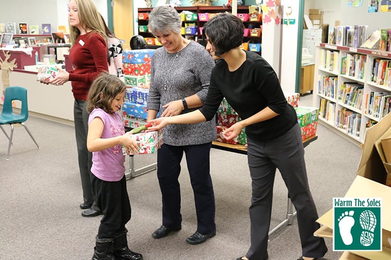 Women passing shoes at a local school