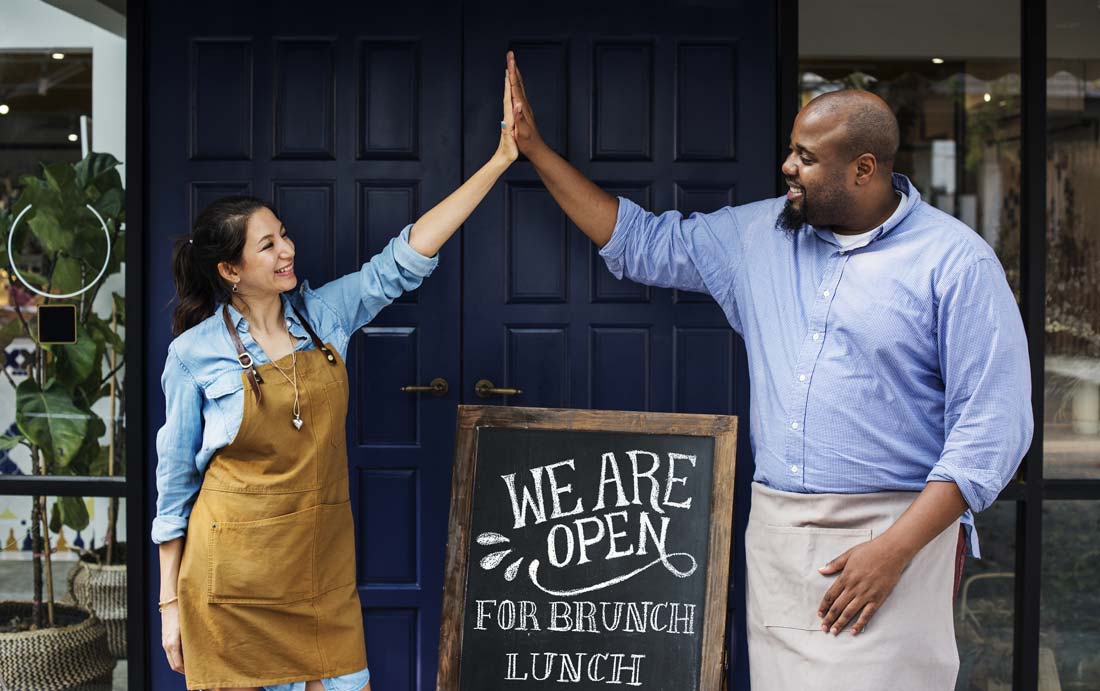 business owners high fiving outside