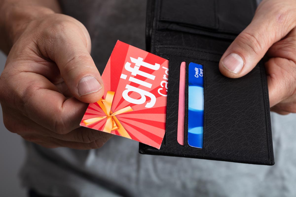 hands holding wallet with gift card