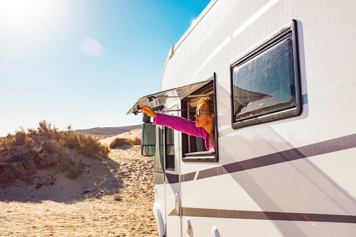 A woman enjoying the sunrise from the camper she bought after getting an RV loan pre-approval.