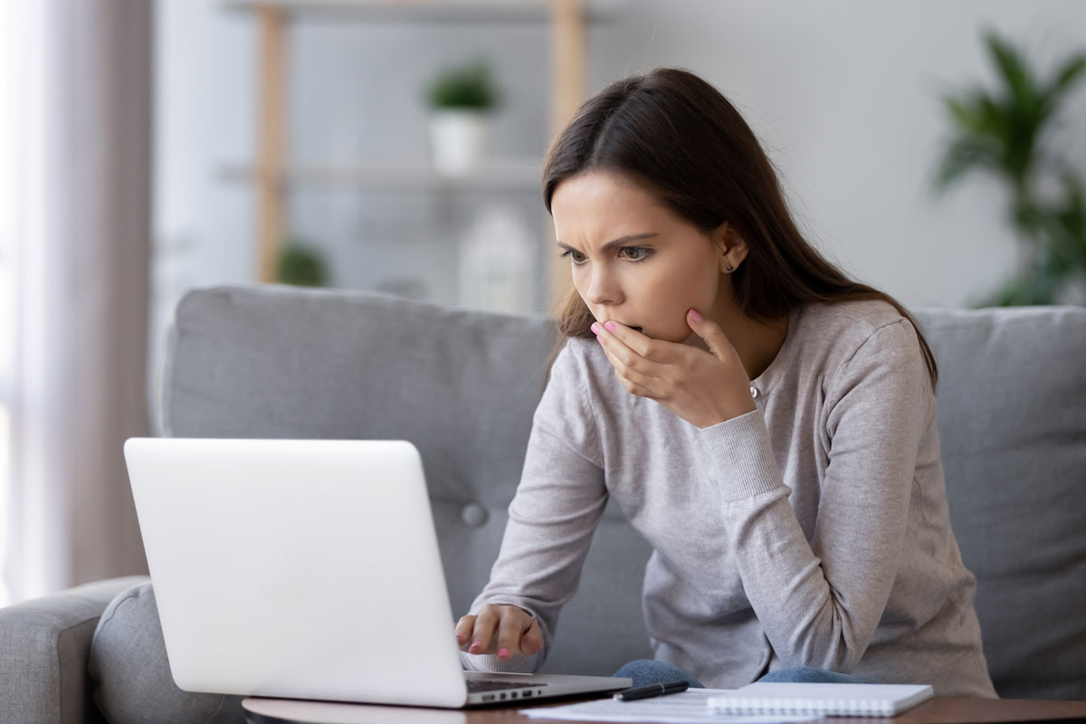 shocked woman looking at laptop