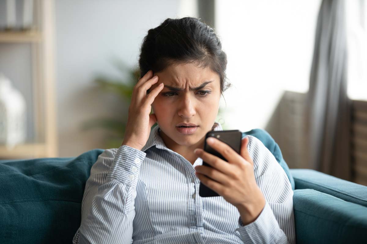 Thoughtful woman looking at phone