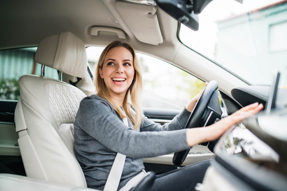 woman smiling and driving car